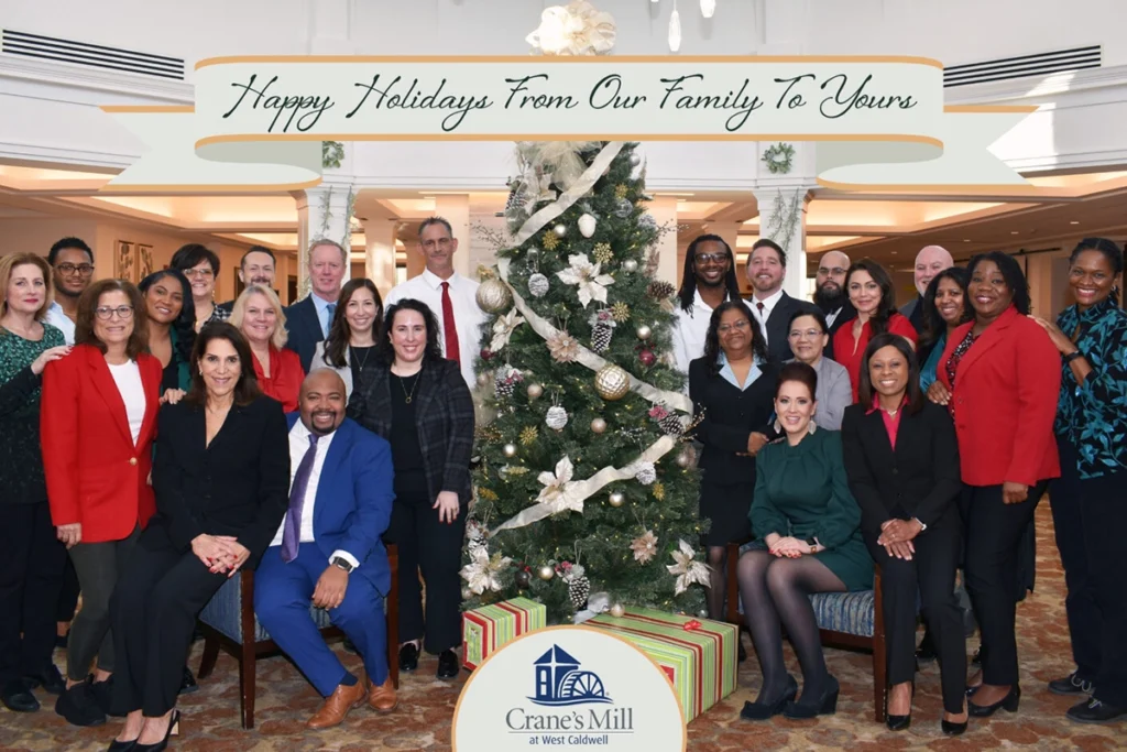 Crane's Mill staff gathered around a Christmas Tree