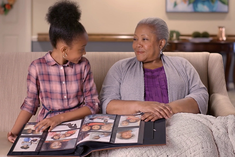 Grandmother and granddaughter looking at photo album