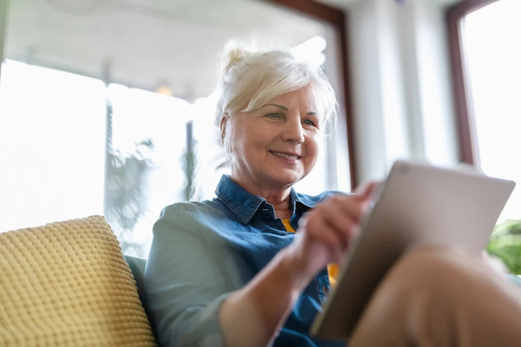 Mature woman reading blog post on tablet