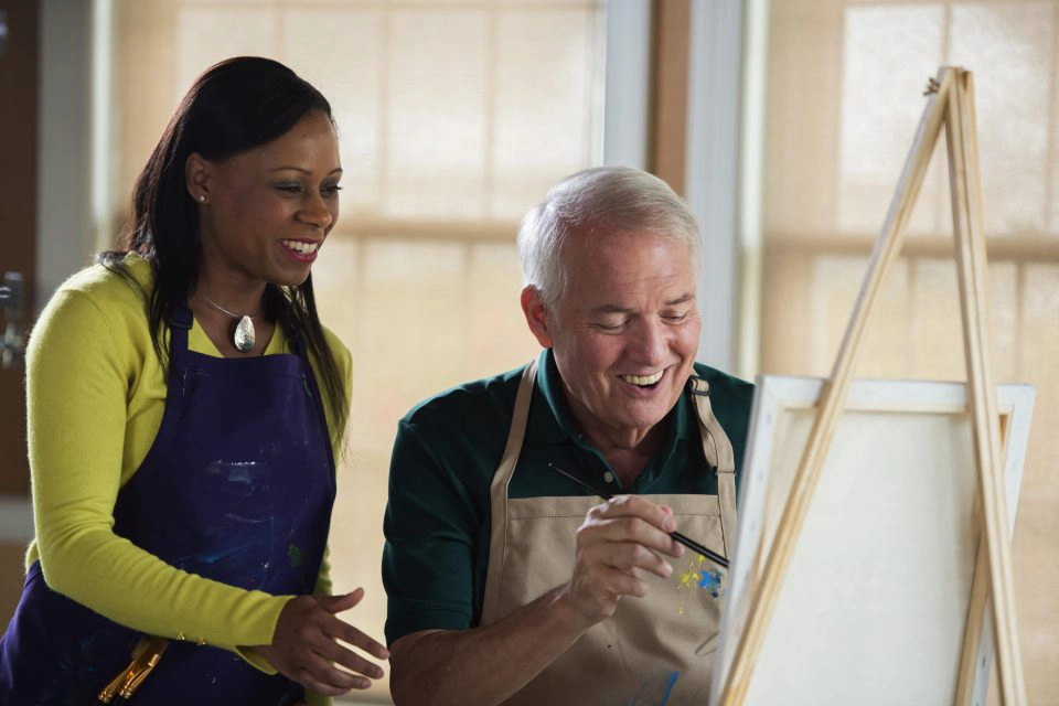 Man painting with staff member